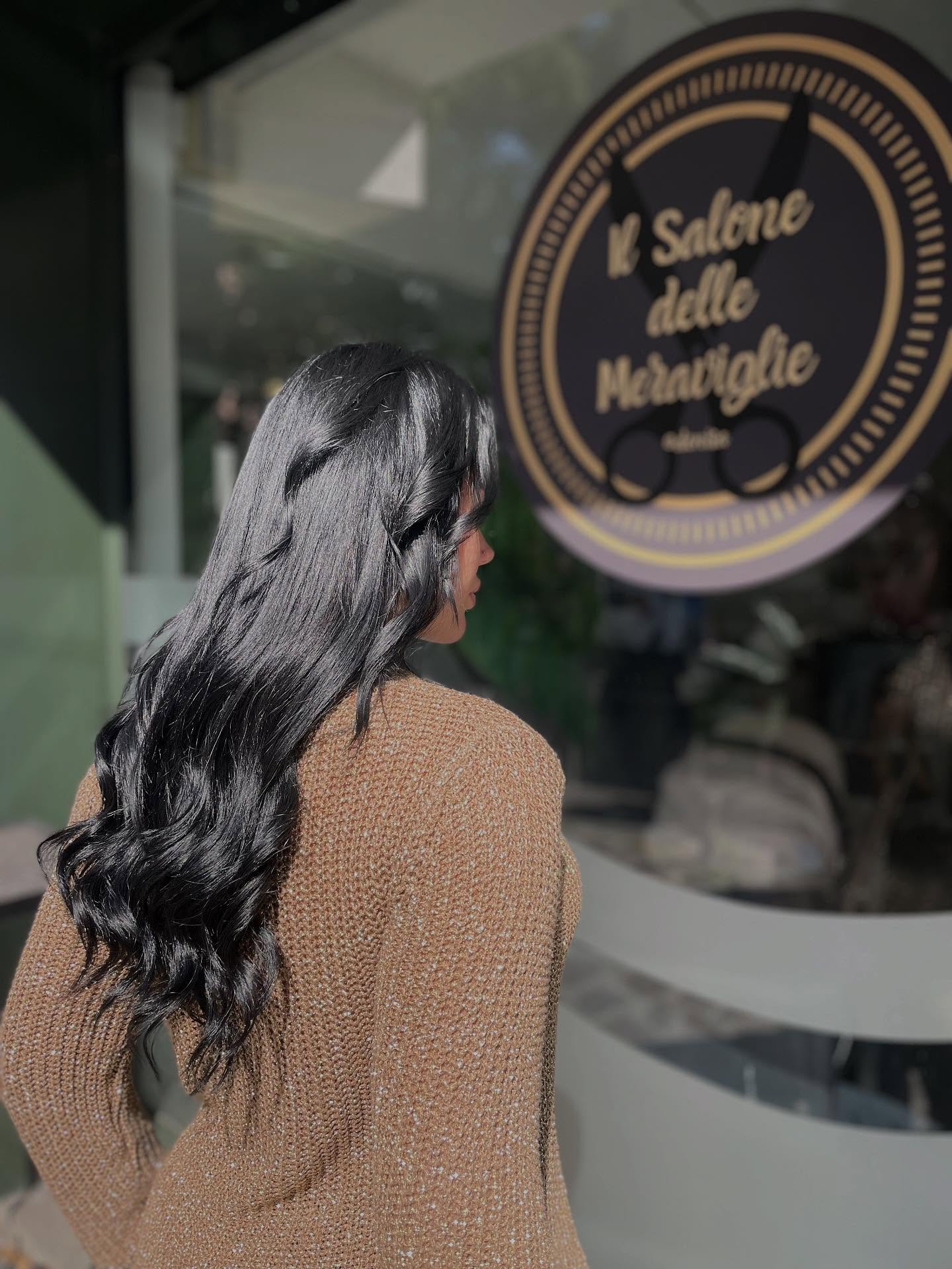Capelli neri lucidi davanti alla vetrina del salone