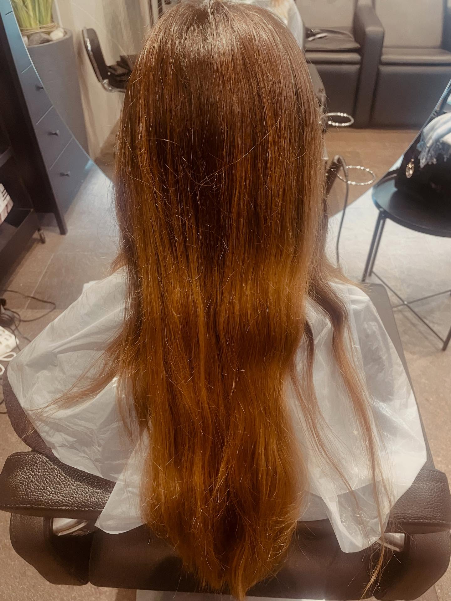 Capelli lunghi ramati e lisci in poltrona